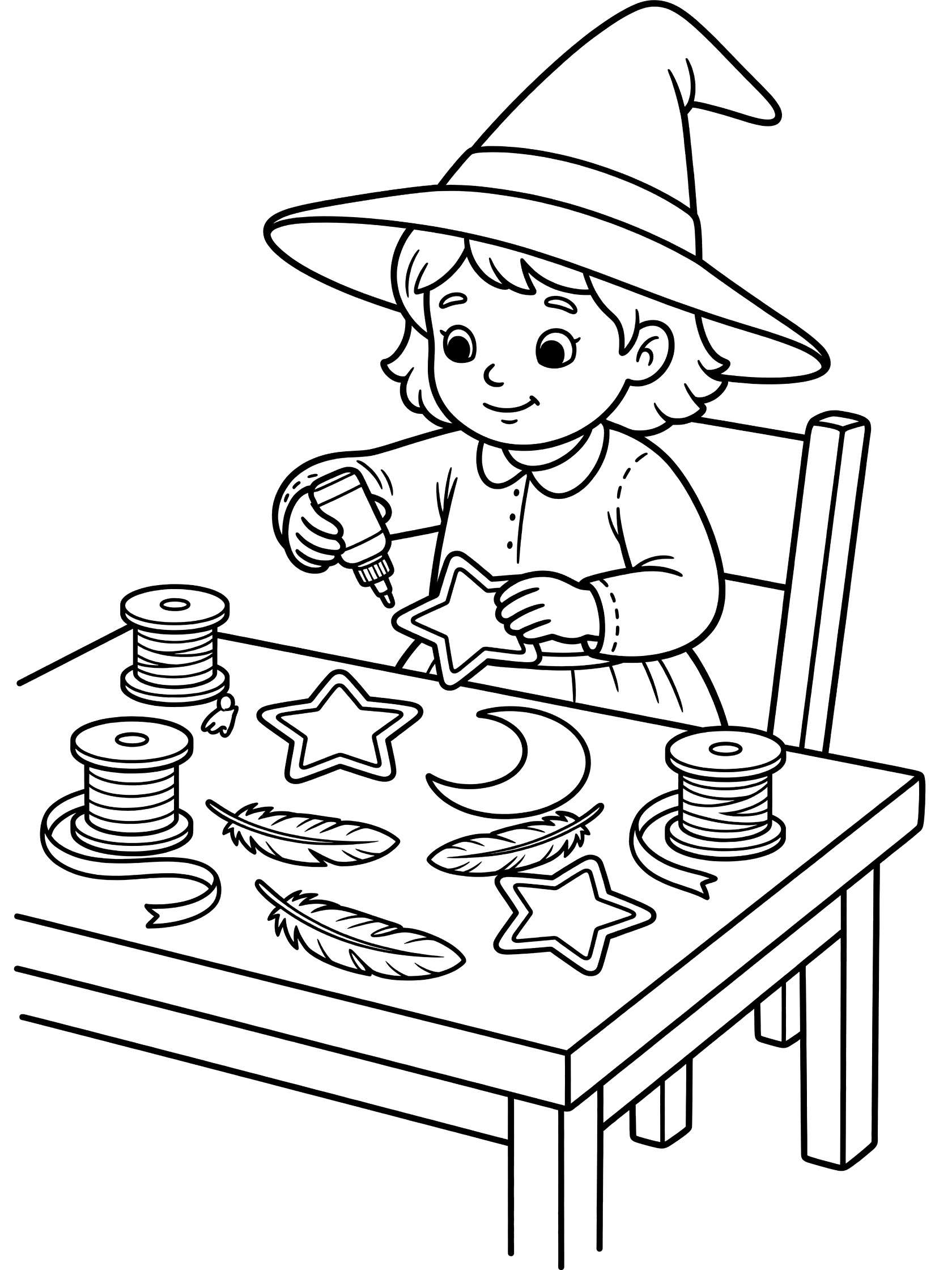Black and white line art coloring page showing a young witch girl sitting at a table, gluing star and moon shapes onto her big pointed witch hat, with spools of ribbon, feathers nearby. Young Witches themed black and white printable line art